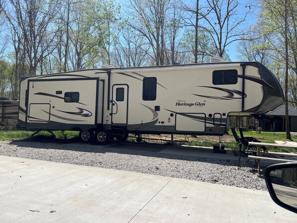A recreational vehicle with a slide-out awning, a kitchen area, and a designated sleeping area. - Cozy 2 BR RV near Tims Ford Lake in Winchester with WiFi, AC (Winchester)