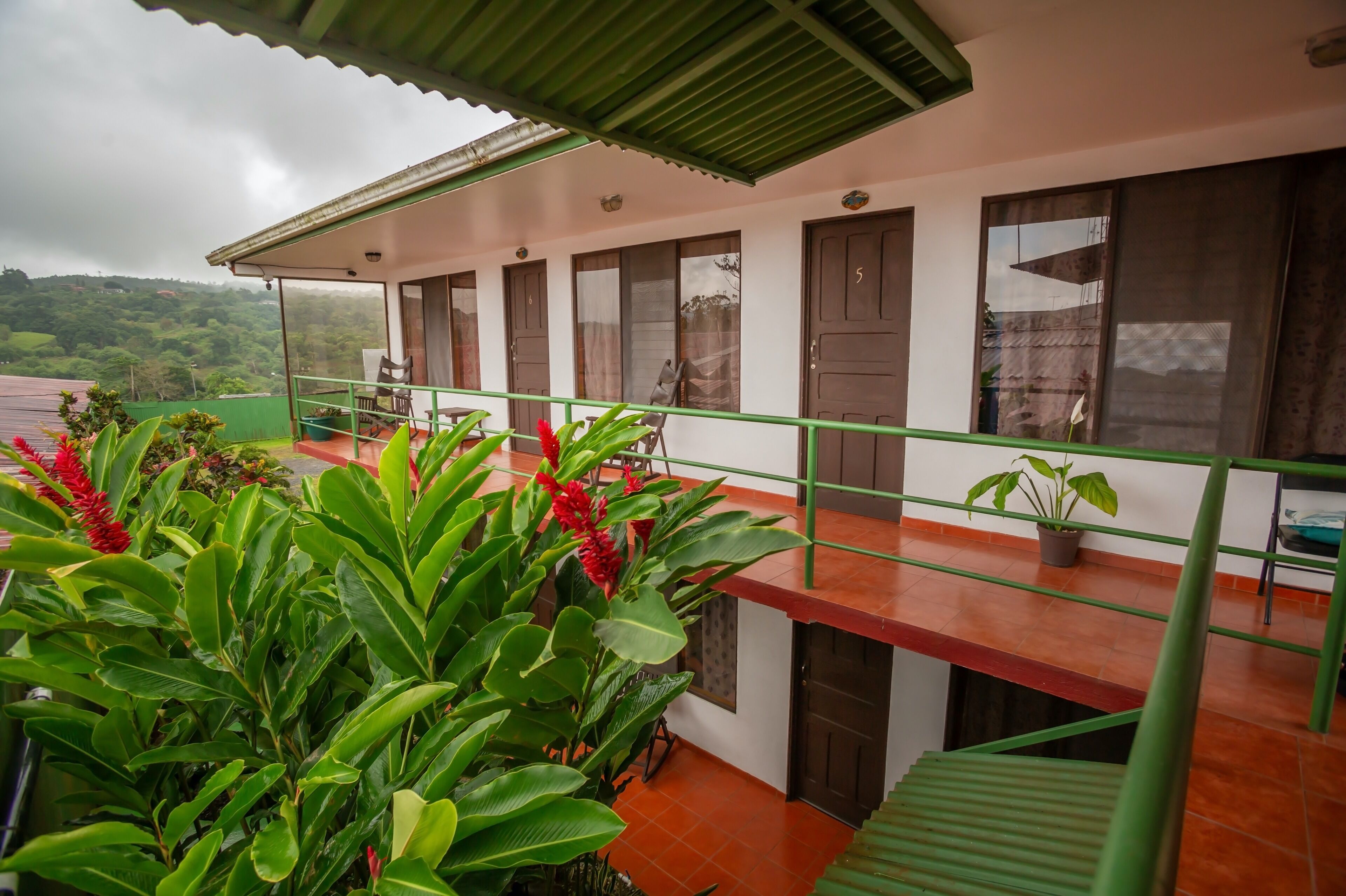 Un hôtel doté d’un balcon, de plantes en pot et offrant une vue sur le paysage environnant.