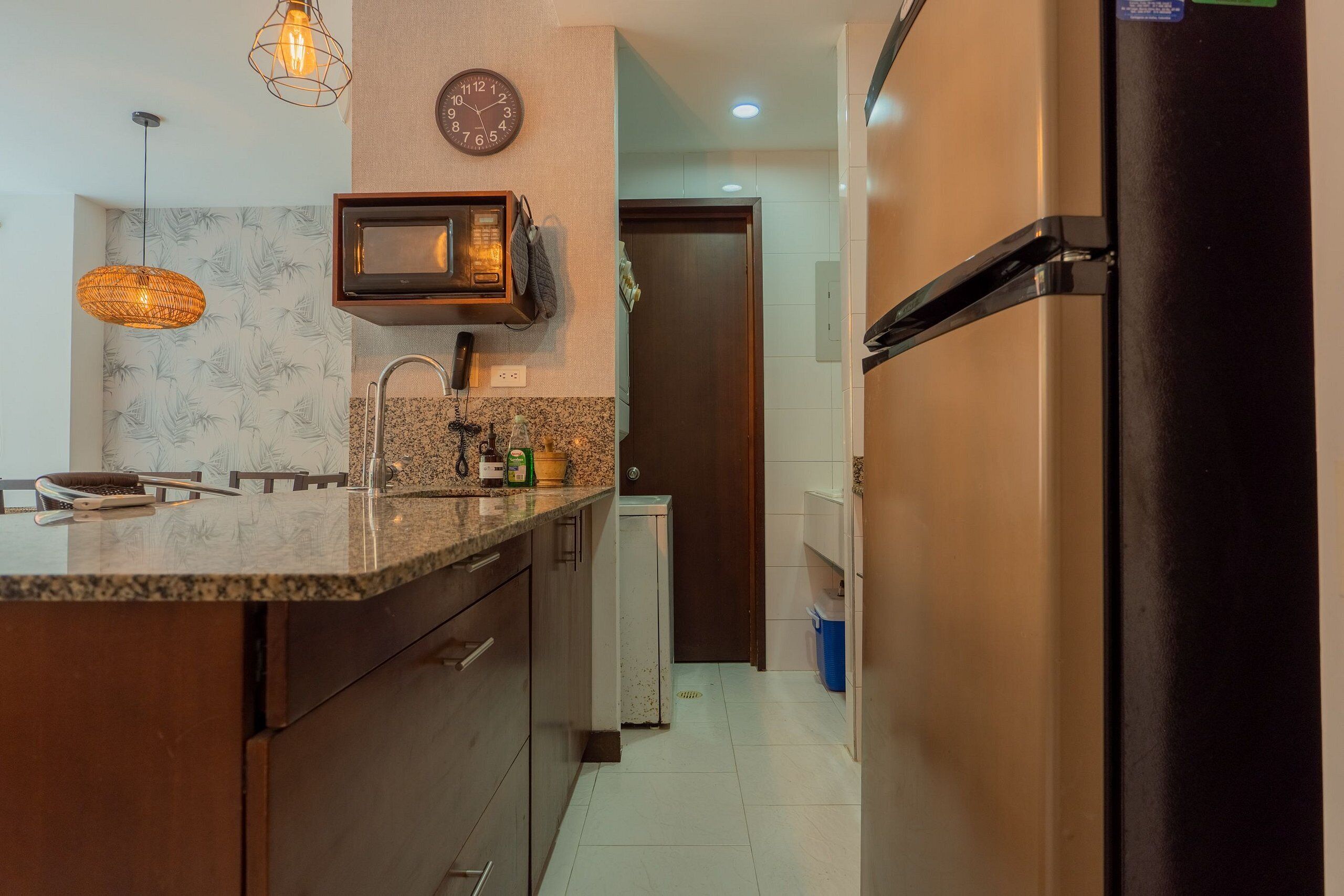 A modern kitchen with a built-in microwave, stainless steel appliances, and a granite countertop.