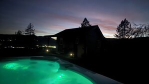 A hot tub with green lighting, a house, and a twilight sky. - 4BR Ranch Retreat w/Hot Tub & Senic Valley Views + Mini House Add-On (Kamiah)