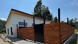 A modern building with a white exterior and a wooden extension. - House in tranquil Tamworth NH with AC, Hot Tub, Riverfront access (Tamworth)