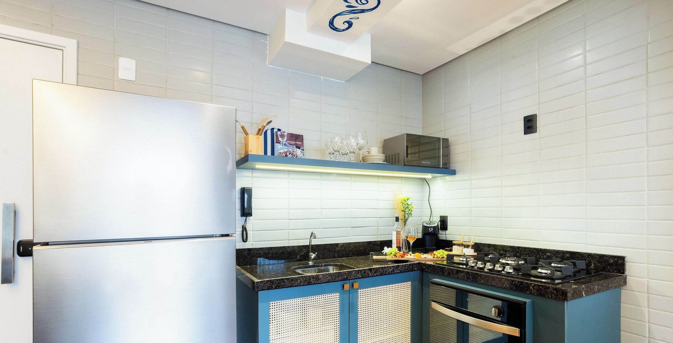 A modern kitchen with a stainless steel refrigerator, a microwave, a sink, and a gas stove.
