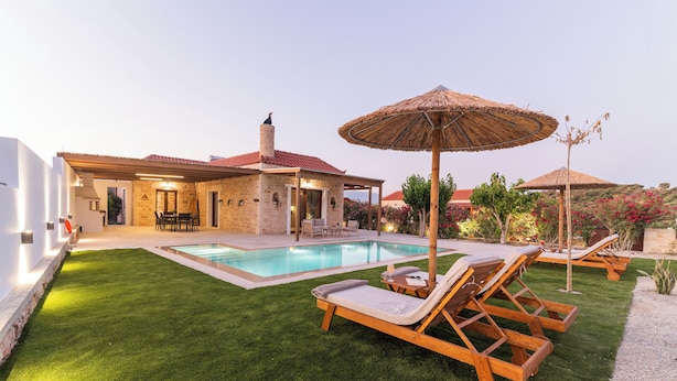 A poolside area with a swimming pool, lounge chairs, and a covered seating area.