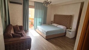 Een slaapkamer met een bed, een bank en een nachtkastje.
