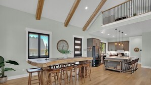 A spacious kitchen with a central island, wooden bar stools, and a view of the outside. - Luxurious Lakefront retreat with own private dock. (Chapin)