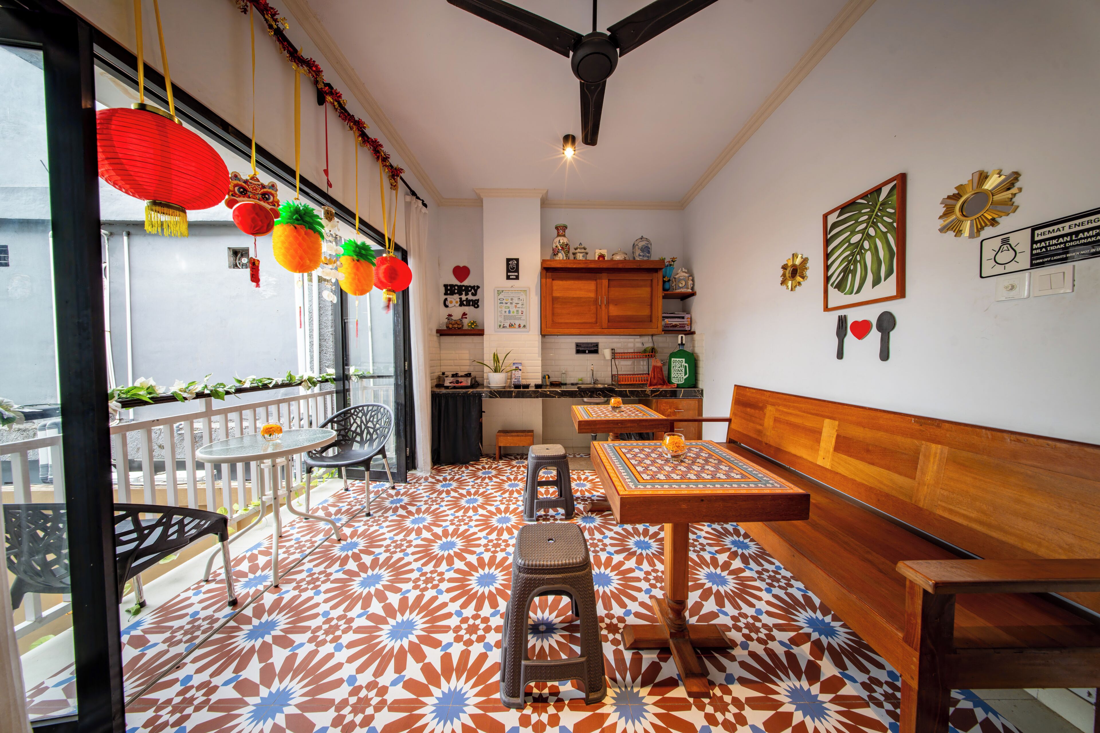 Un comedor con suelo estampado, una mesa con taburetes y un ventilador de techo.