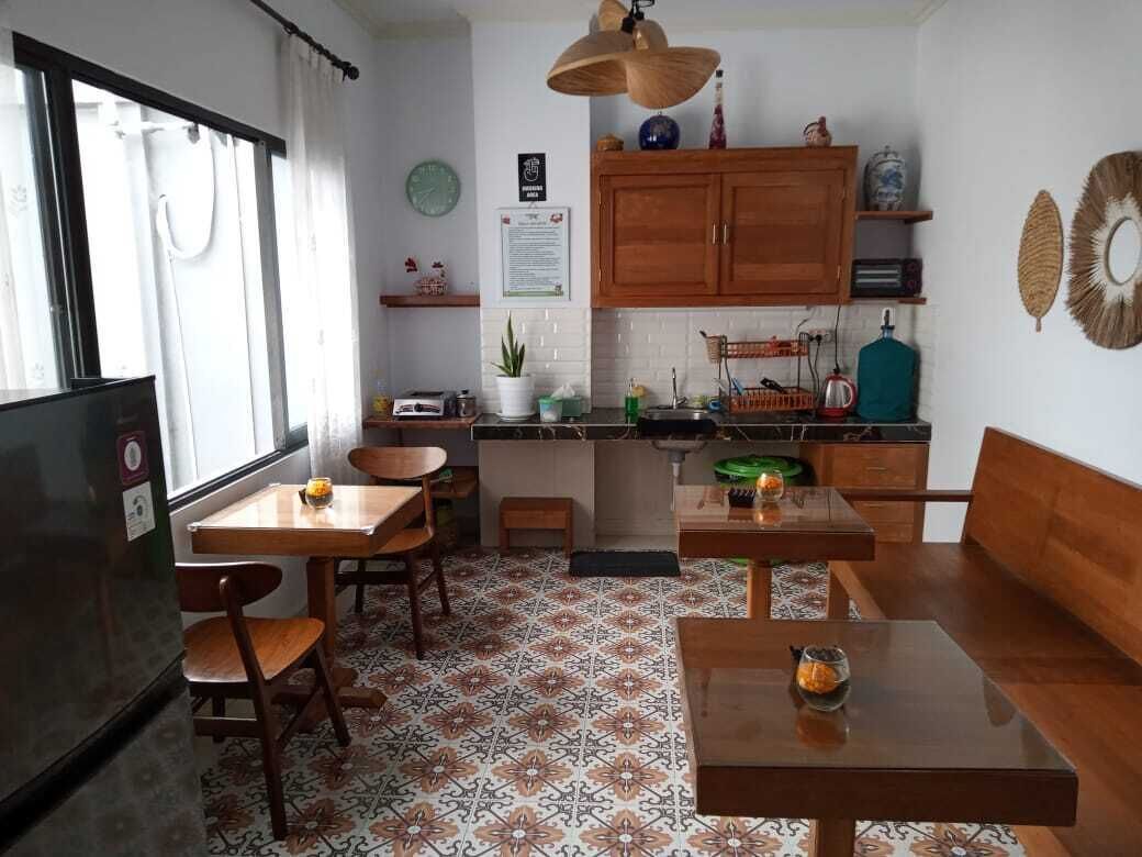 A compact kitchen with wooden cabinets, a dining table, and chairs.