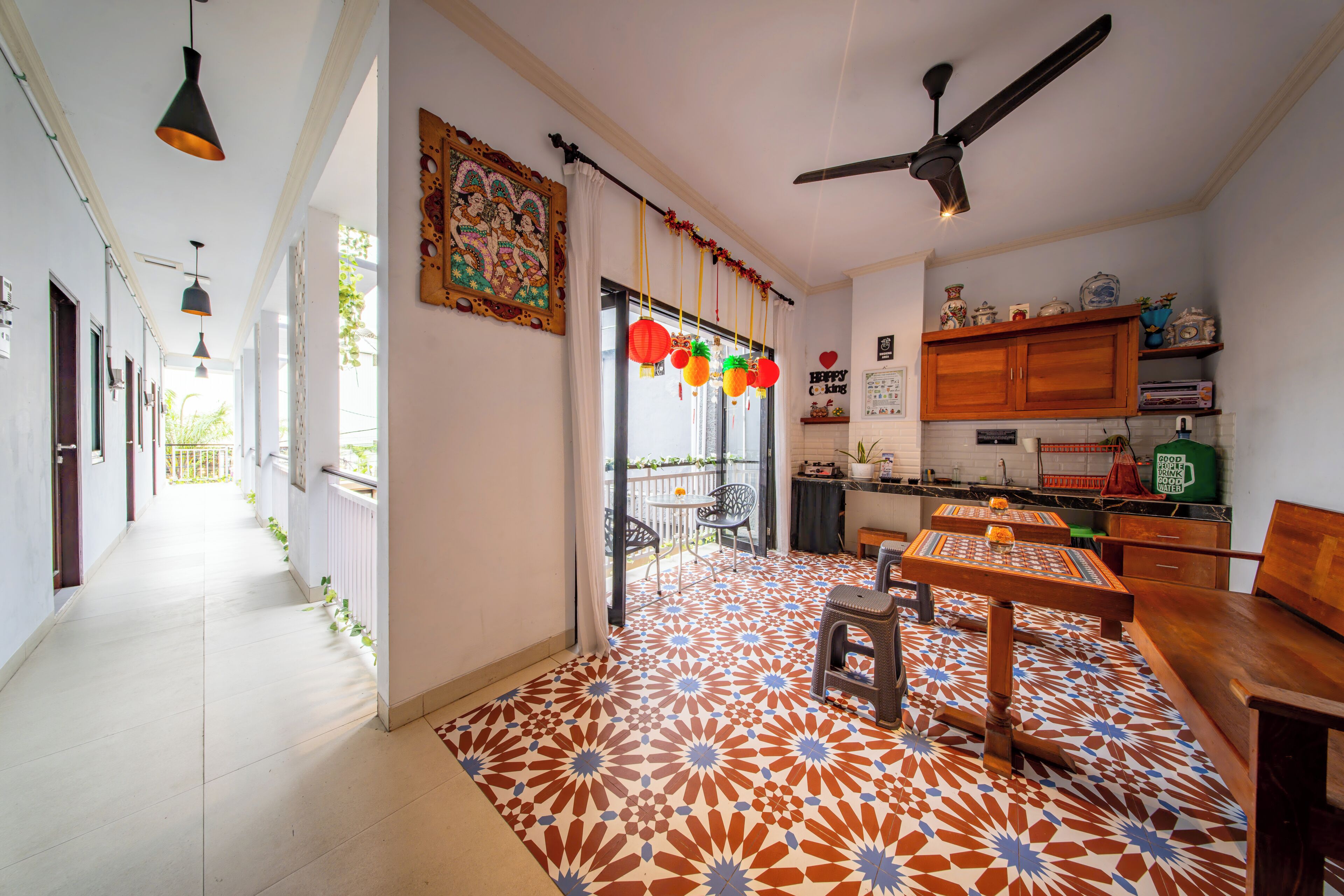 Una cocina amplia con comedor, que cuenta con piso estampado, ventilador de techo y diversos electrodomésticos.