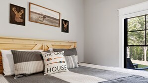 Un dormitorio con cabecera de madera, un ventanal grande y tres adornos de venado colgados en la pared.