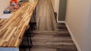 A narrow hallway with a long wooden table and chairs, leading to a door at the end. - Charming 5-bdrm hotel with AC, WiFi in serene Fulton, Arkansas. Private baths. (Fulton)