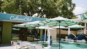 A pool area with umbrellas, lounge chairs, and a 'CabanaClub' sign. - Tucked Away Stay in East ATX (Austin)
