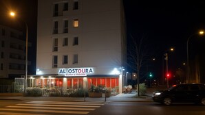 A modern hotel with a sign reading "AL OSTOURA Buffet à Volonte" at night. - Studio Near LDLC ARENA OL (Décines-Charpieu)