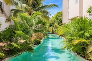 Una piscina circondata da vegetazione rigogliosa e edifici.