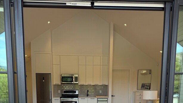 Un intérieur moderne comprenant une cuisine, un coin repas et une chambre avec un grand lit.