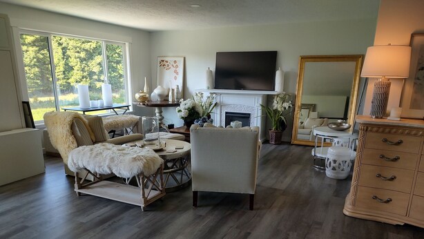 A modern living room with a fireplace, a television, and a dining area.