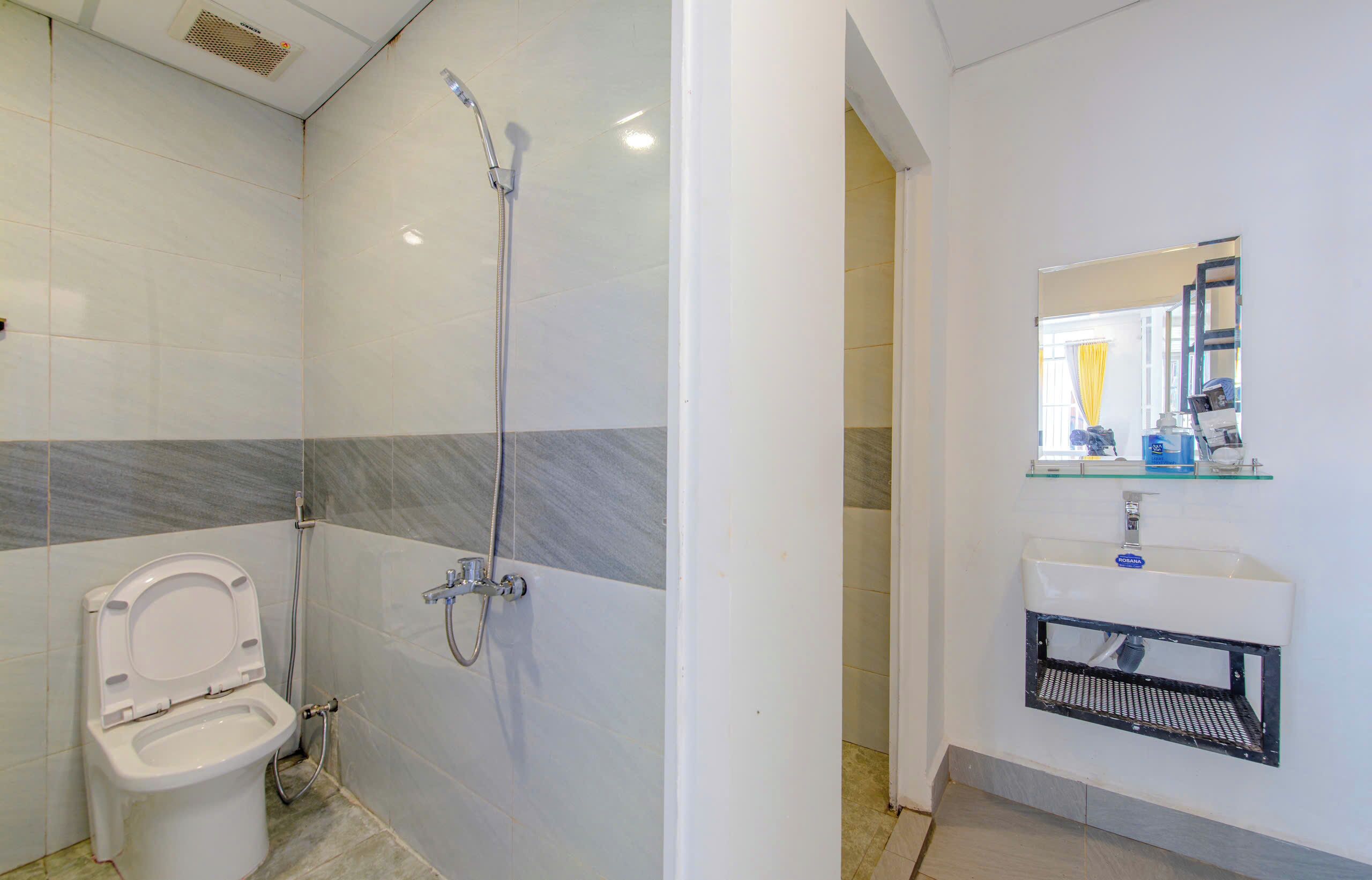 A modern bathroom with a toilet, shower, and sink.