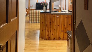Un intérieur en bois comprenant un coin cuisine, une table à manger et un canapé.