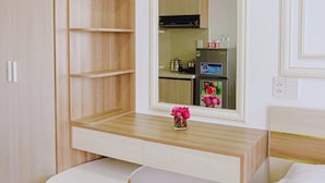 Ein modernes Zimmer mit einem hölzernen Schminktisch, einem Spiegel und einem kleinen weißen Tisch.