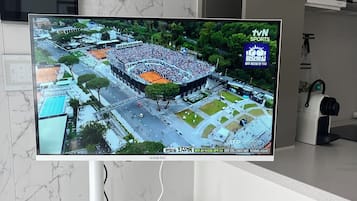 A television mounted on a wall displaying a sports event.
