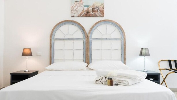 A neatly made bed with white linens, two bedside lamps, and a painting on the wall. - Charming 3-bedroom house with AC, WiFi in amazing Hollywood (Hollywood)