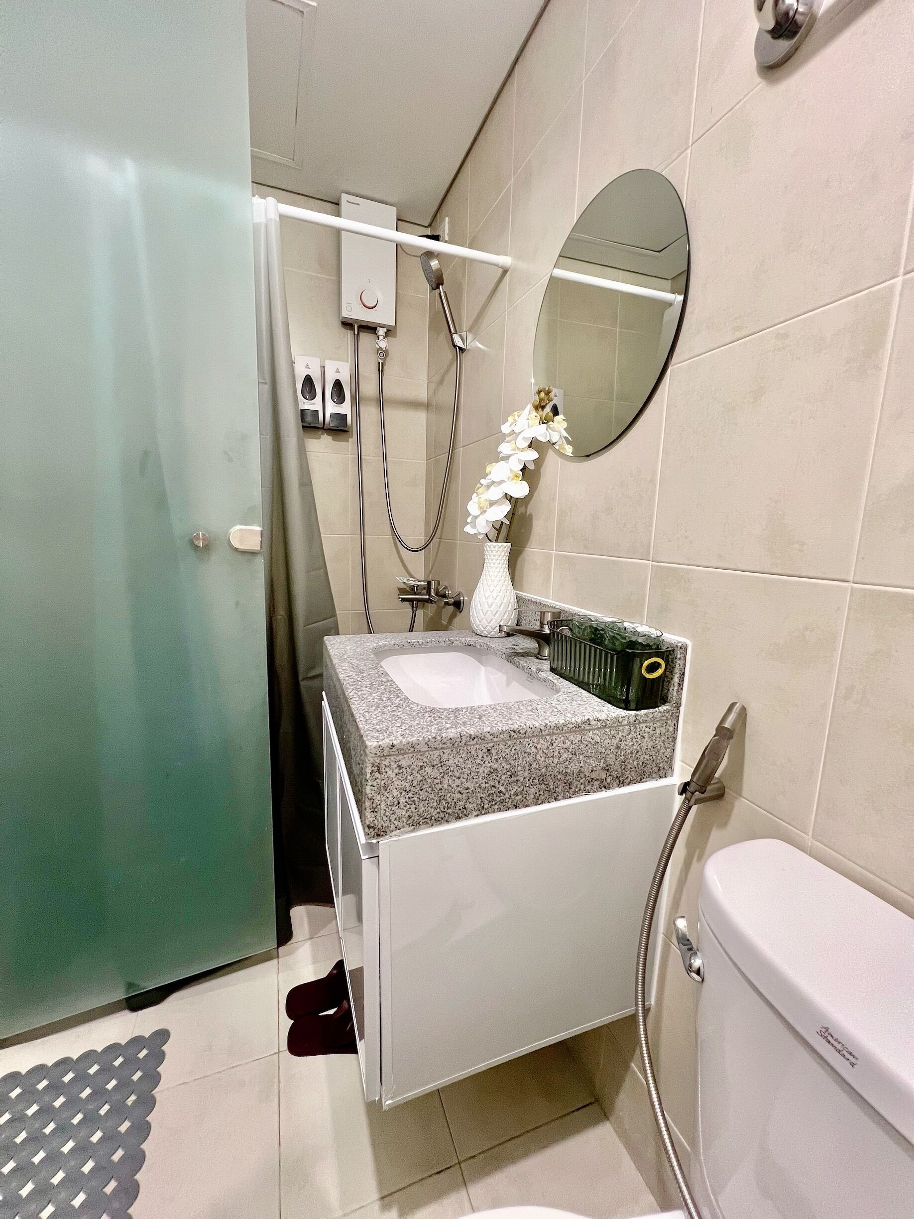 Un baño con inodoro, lavamanos y ducha.