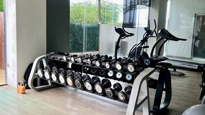Une salle de sport moderne, dotée d’une variété d’équipements, notamment des haltères, un banc et des appareils d’exercice.