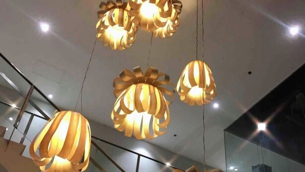 Un intérieur moderne avec un escalier et des suspensions au design original, évoquant un ruban.