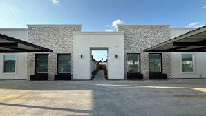 A modern building with a stone facade, large windows, and a central entrance. -  Brand New, Spacious & Stylish – Your Perfect Getaway Awaits! (Mission)