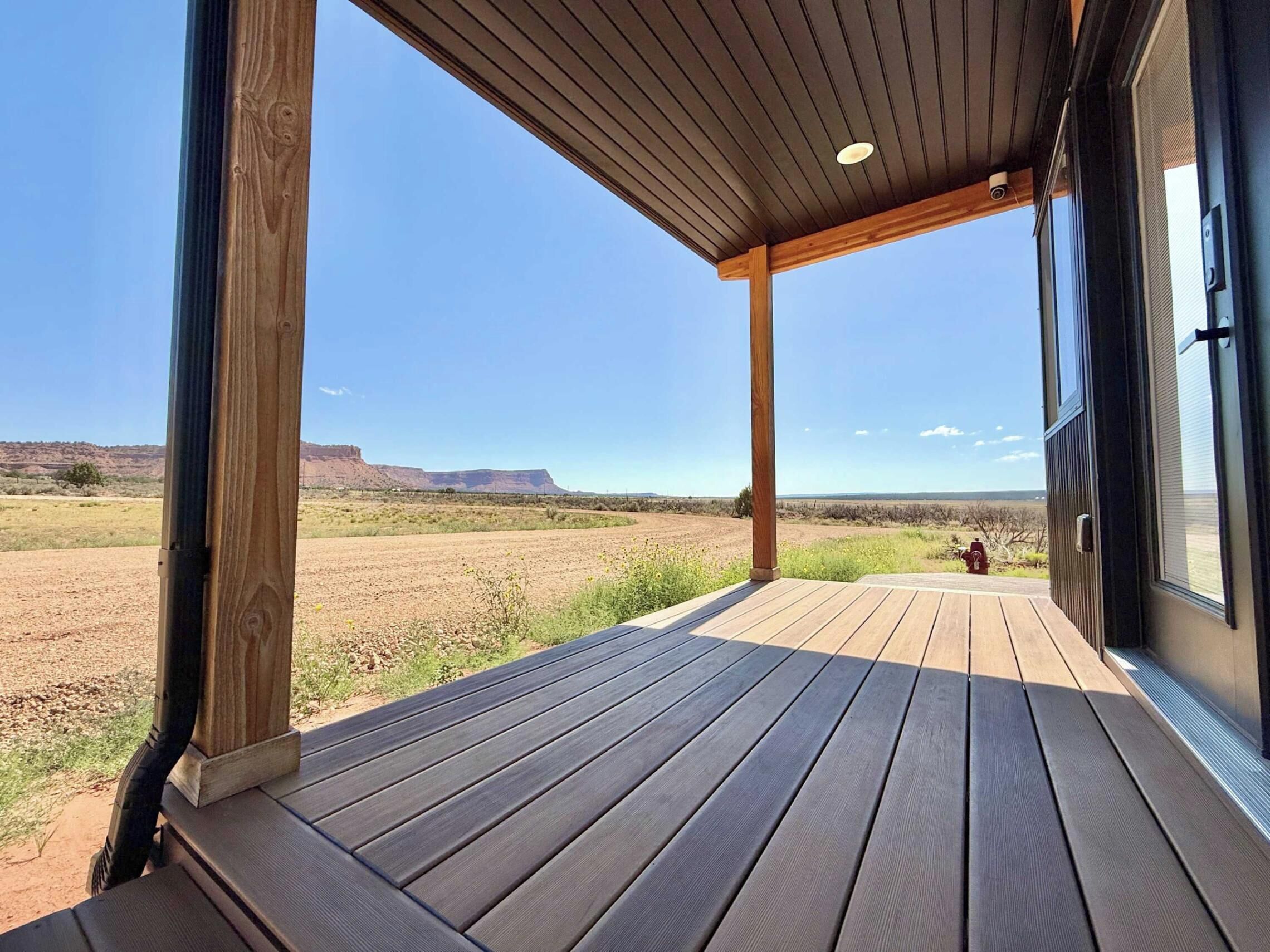 A wooden deck with a view of a desert landscape.
