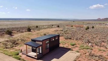 A modern, single-story building with a flat roof, situated in a desert landscape with sparse vegetation.