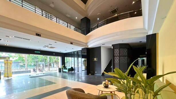 A spacious lobby with a high ceiling, a staircase, and a seating area with a plant. - The Estella Hotel Klang (Klang)