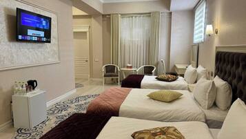 Habitación triple Deluxe, vista a la ciudad | Caja de seguridad en la habitación, cortinas blackout y insonorización