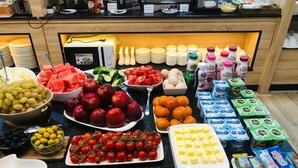 A buffet with various food items including fruits, vegetables, dairy products, and condiments. - al Madina Hotel Samarkand  (Samarkand)