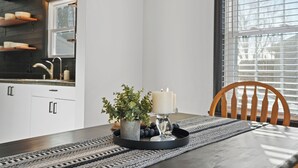 Et spisebord med et lysdække, en potteplante og en bakke med druer.