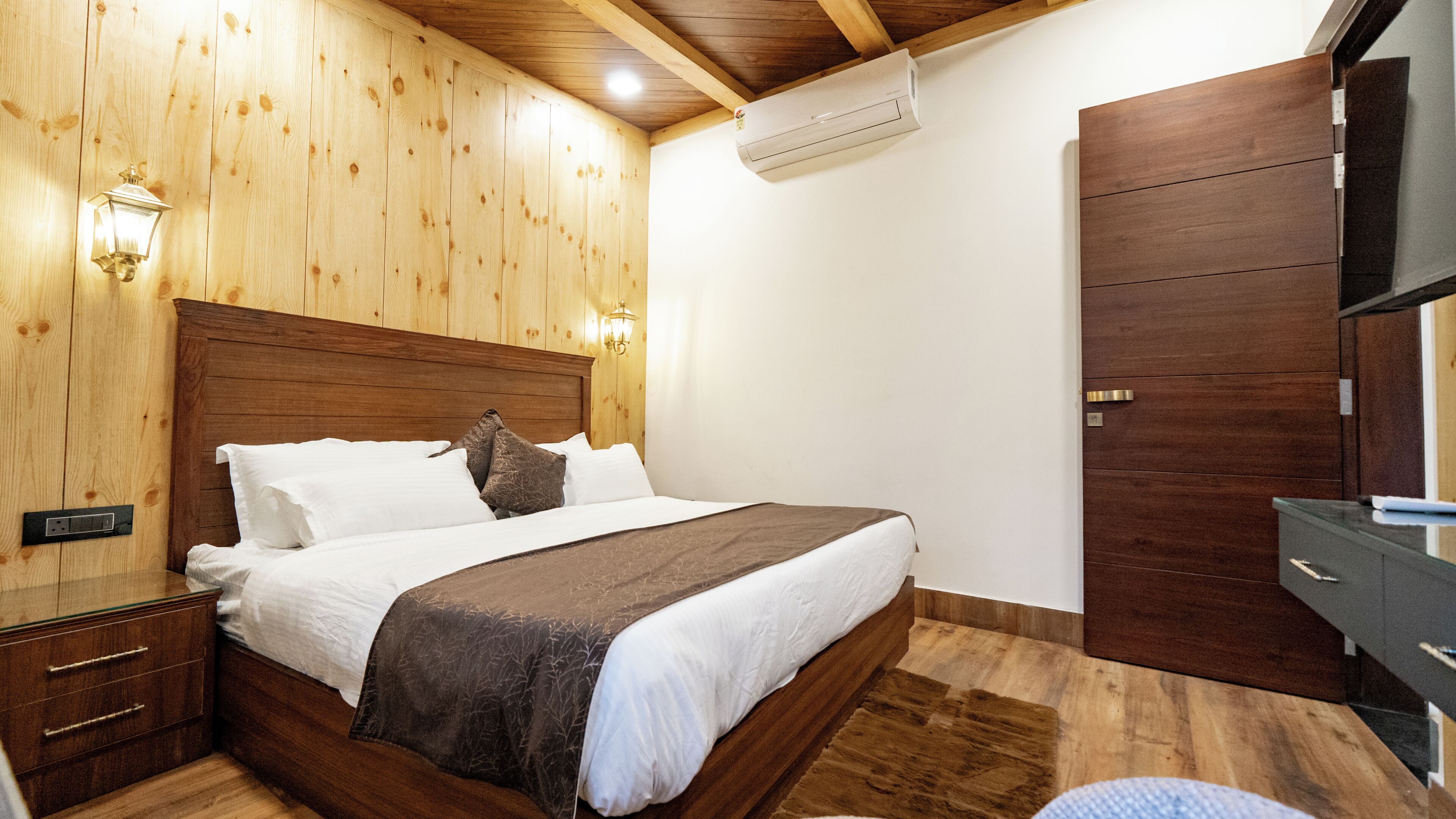 Un dormitorio con paneles de madera, una cama, mesitas de noche y un armario.