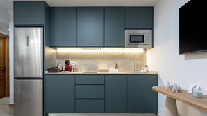 Une cuisine moderne avec des armoires de couleur turquoise, des appareils en acier inoxydable et un plan de travail en bois.