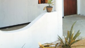 A white exterior wall with a wooden door and a window.