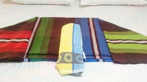 A bed with a colorful blanket and two white pillows.