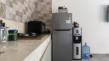 Una cuina amb un frigorífic d'acer inoxidable, una cuina de gas i un dispensador d'aigua.