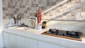 Habitación Deluxe, tina, vista a la alberca | Cocina privada | Refrigerador, microondas, parrilla de estufa y plancha de cocina