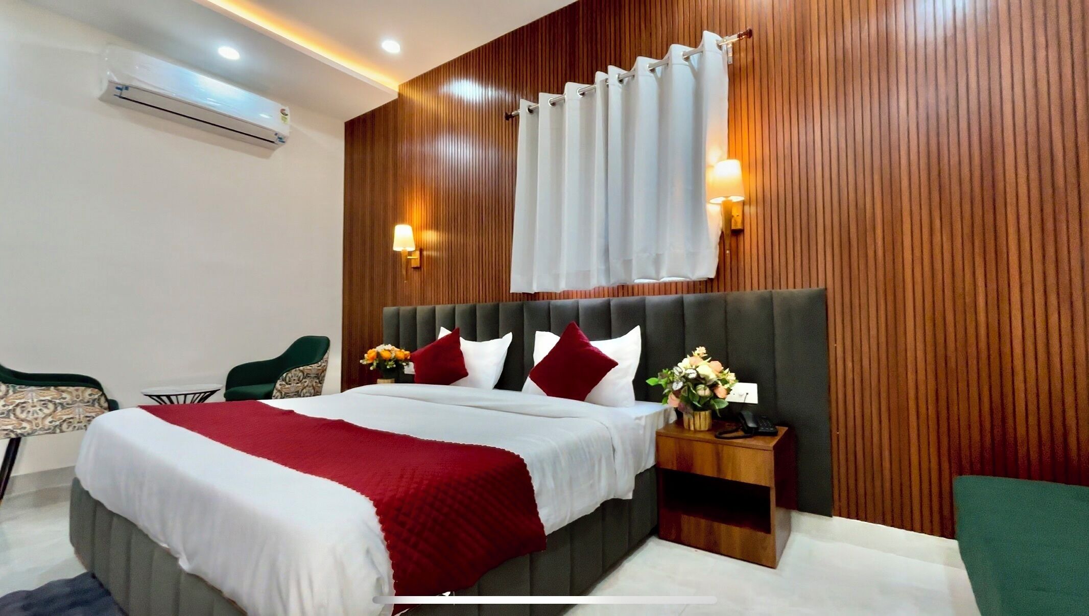Ein Hotelzimmer mit Bett, Nachttisch, Lampe und Holzvertäfelung.