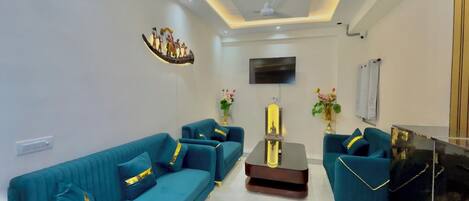 Una sala de estar moderna con sofás color turquesa, una mesa de centro y jarrones decorativos.