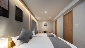 Una habitación de hotel moderna con dos camas, un escritorio, una silla y una mesita.
