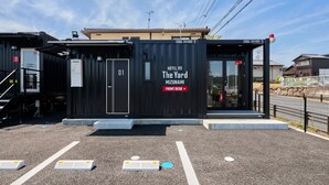 A compact hotel named "The Yard Mizunami" with a front desk area, a small outdoor seating space, and a visible entrance. - HOTEL R9 The Yard Mizunami (Mizunami)