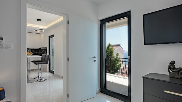 Un intérieur moderne comprenant une cuisine, un coin repas et un balcon avec vue.