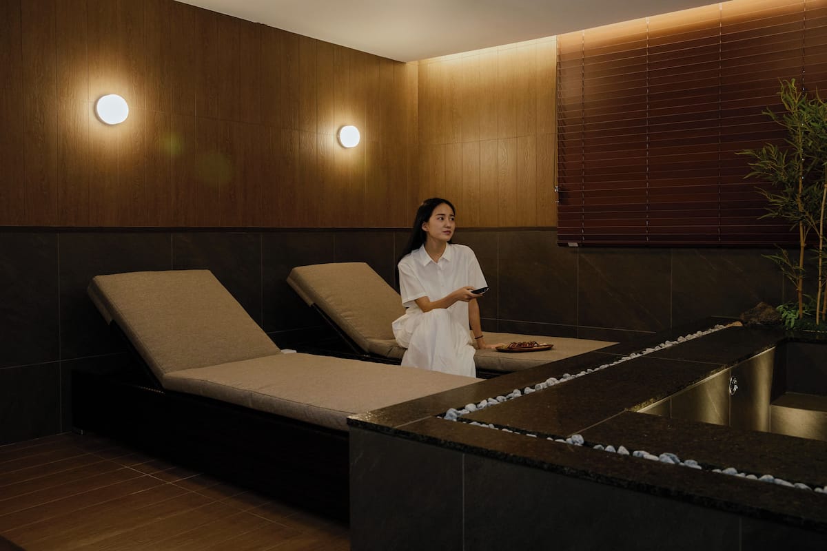 A spa room with two massage chairs, a stone counter, and wooden walls.