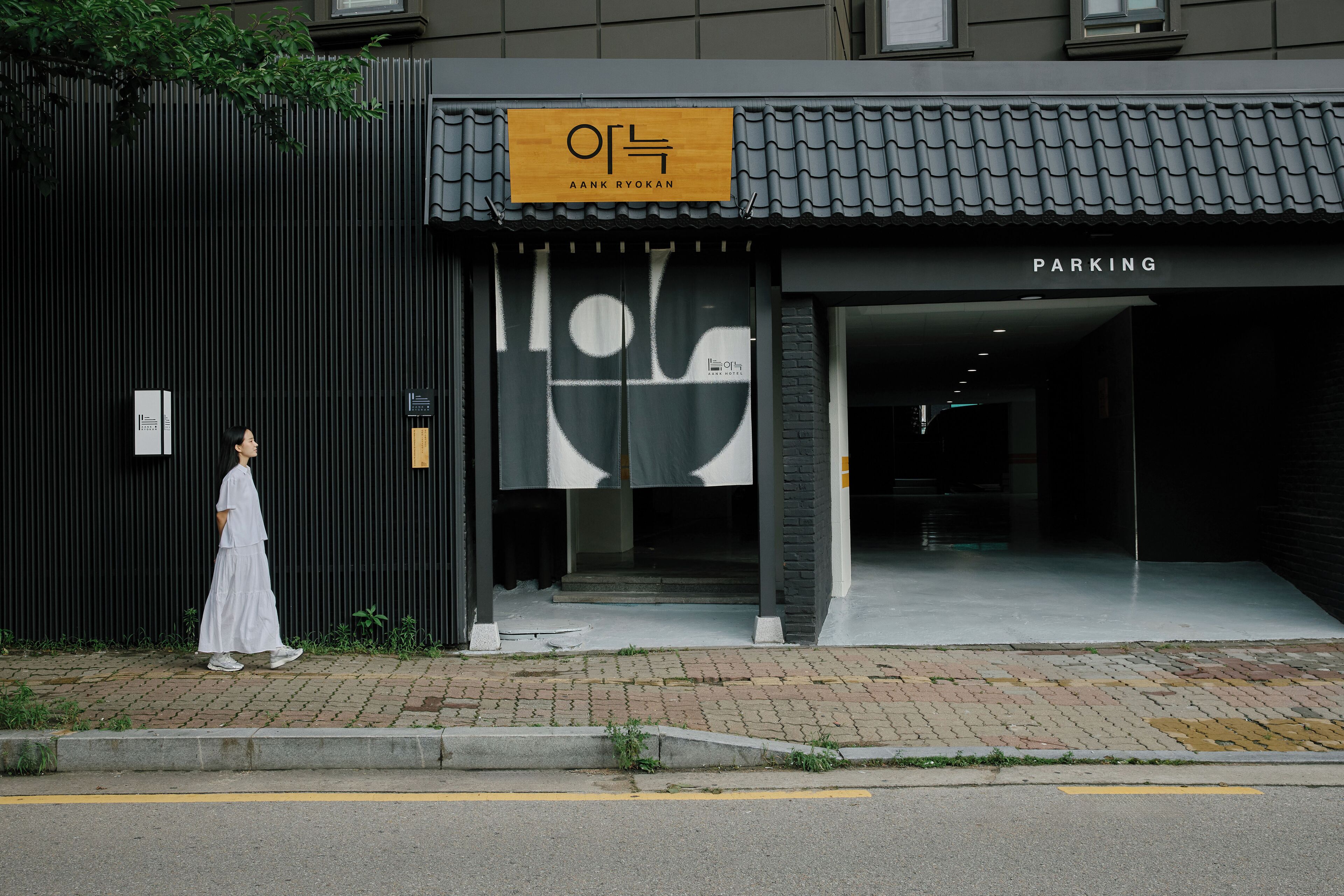 A building with a sign reading "AANK RYOKAN" and a "PARKING" sign.