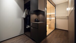 A compact room with a kitchenette, wooden flooring, and a sliding door closet. - Anook Ryokan Hotel Suwon (Suwon)