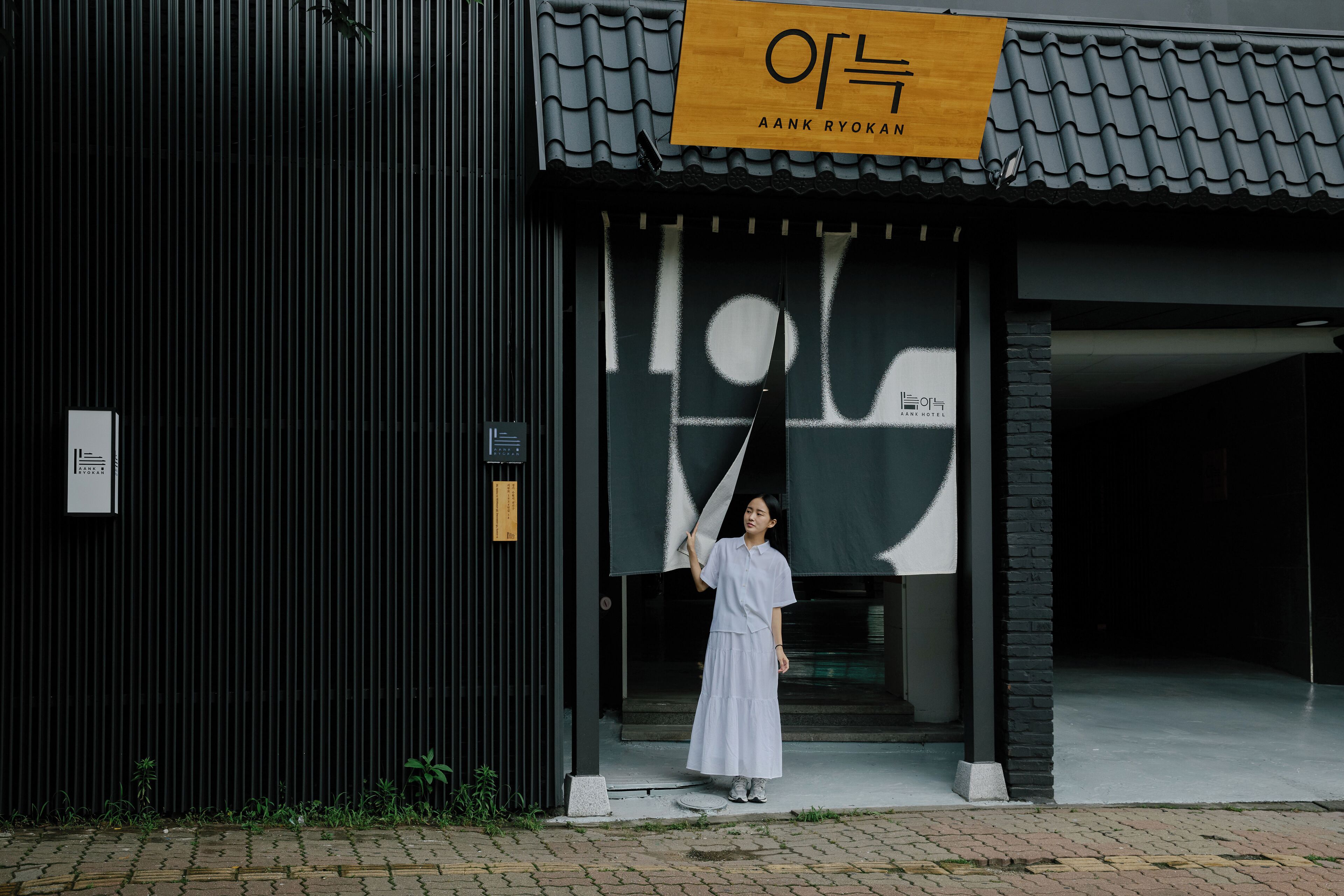 A modern building with a sign reading 'AANK Ryokan'.
