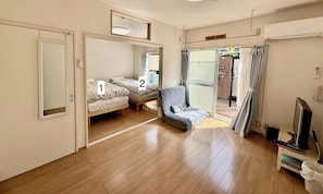 Une chambre avec deux lits, un petit coin salon et une télévision.